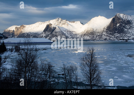 Mefjordbotn pesca costiera borgo incastonato tra le montagne senja inverno artico Norvegia Foto Stock
