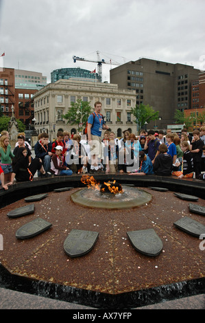 Un gruppo di studenti che si raccolgono intorno ad una guida turistica come egli parla di Canadas Parliament Hill Foto Stock