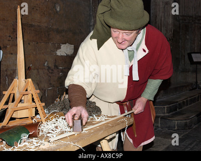 Uomo vestito in abiti tradizionali facendo una freccia nel chiostro della cattedrale di Norwich Norfolk England Regno Unito Foto Stock