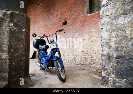 Ciclomotore blu parcheggiata vicino al vecchio edificio, Regensburg, Germania Foto Stock