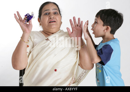 Ragazzo a spaventare la nonna Foto Stock