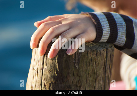 La mano appoggiata sul vecchio weathered palo di legno Foto Stock