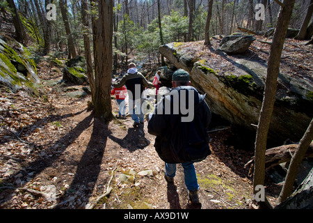 Una famiglia utilizza un hand-held unità GPS per trovare un geocache o Geo cache che è un escursionismo attività dove la gente cerca di scatole Foto Stock