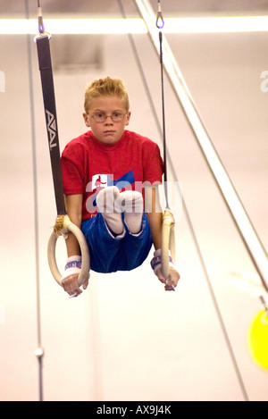 Ragazzo esegue su anelli di ginnastica durante la dimostrazione si incontrano a U S Centro di ginnastica in California USA Foto Stock