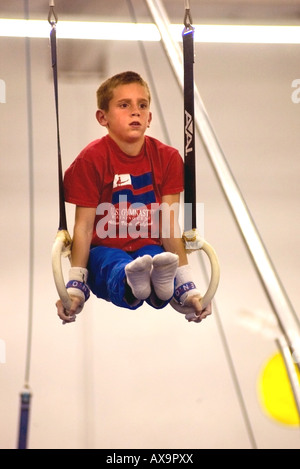 Ragazzo esegue su anelli di ginnastica durante la dimostrazione si incontrano a U S Centro di ginnastica in California USA Foto Stock