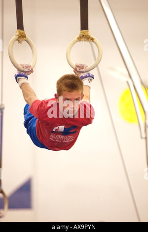 Ragazzo esegue su anelli di ginnastica durante la dimostrazione si incontrano a U S Centro di ginnastica in California USA Foto Stock