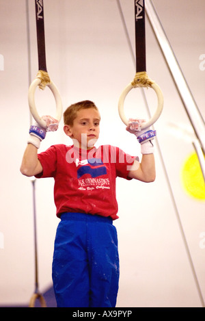 Ragazzo esegue su anelli di ginnastica durante la dimostrazione si incontrano a U S Centro di ginnastica in California USA Foto Stock