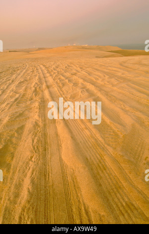 Tracce di pneumatici nelle dune del mare interno (Khor Al Adaid) nel Sud del Qatar. Foto Stock