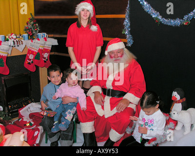 I bambini in visita di Babbo Natale e il suo aiutante nella santa grotta di s Foto Stock