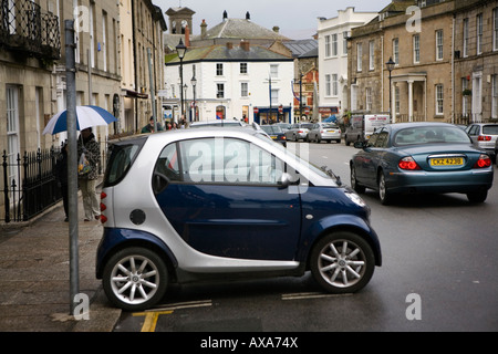 Un 'Smart' automobile parcheggiata lateralmente in una baia di parcheggio in strada di limone, Cornwall Foto Stock