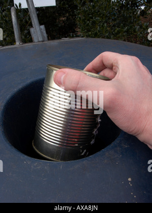 Man mano collocando un vuoto riciclabili grandi metallo pulito possibile in un contenitore di riciclaggio al deposito di riciclaggio Foto Stock