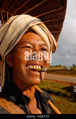 La donna lavoratrice agricola fumare una cheroot verde in Birmania Myanmar Foto Stock