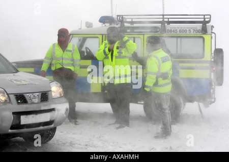 Tayside e Grampian Ufficiali della Polizia in pieno inverno meteo abbigliamento in una tempesta di neve a Glenshee, Aberdeenshire, Scotland, Regno Unito Foto Stock