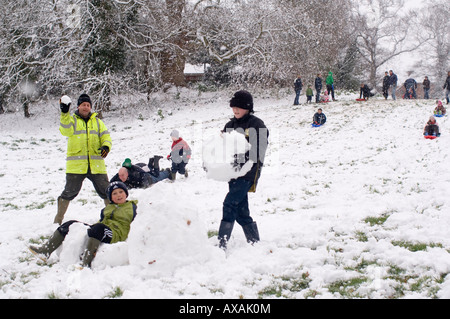 Persone a giocare nella neve in Dell a Beccles Foto Stock