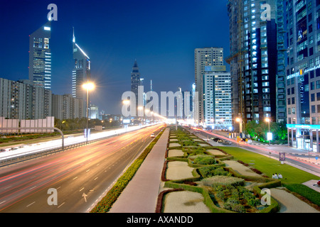 Una vista del tramonto di percorsi di traffico e gli edifici lungo lo sceicco Khalifa Bin Zayed Road a Dubai. Foto Stock