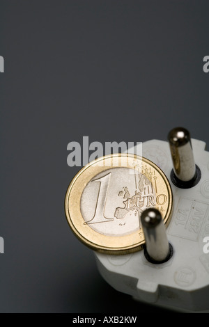 1 Euro moneta e il simbolo di una spina di energia elettrica energia tasso di prezzo Foto Stock