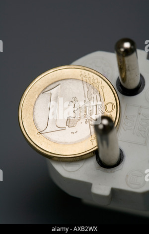 1 Euro moneta e il simbolo di una spina di energia elettrica energia tasso di prezzo Foto Stock
