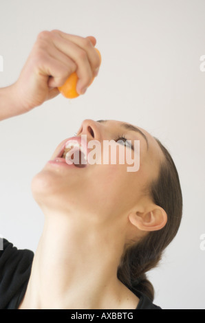 Giovane donna sana bevande spremuta di arancia fresca Foto Stock