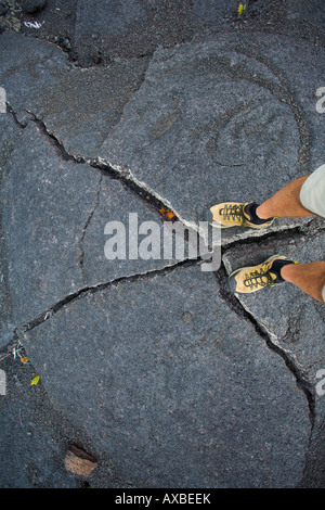 Un uomo in piedi e gambe in piedi su uno sconvolgimento in un vecchio flusso lavico in Hawai i vulcani Parchi nazionali Foto Stock