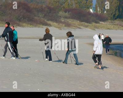 In autunno groupe di persone facendo nordic fitness passeggiate sulla spiaggia tra la città e di Bansin Heringsdorf Foto Stock