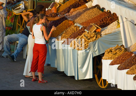 Orizzontale di vista in elevazione di una frutta secca e noci per la vendita su uno stallo nel 'Place Jemaa El Fna' con i turisti in cerca di produrre Foto Stock