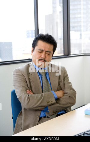 Imprenditore con le braccia incrociate Foto Stock