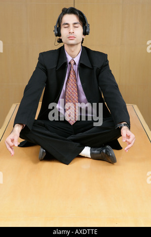 Imprenditore facendo yoga in un ufficio tabella Foto Stock