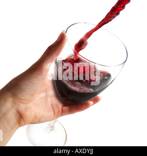 Il vino rosso è versata in un bicchiere da vino tenuto da una donna mano contro uno sfondo bianco Foto Stock