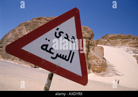 Segnale stradale arabo, Egitto, Africa. Cartello di avvertimento con la Duna di sabbia bianca visibile sullo sfondo, deserto del Sinai, Dahab, Egitto. Foto Stock