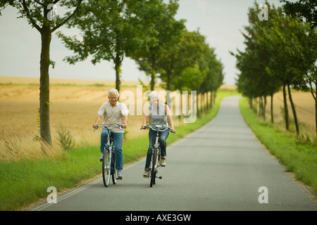 Coppia senior ciclismo su strada di campagna Foto Stock