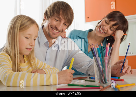 La ragazza (8-9) pittura con i genitori Foto Stock