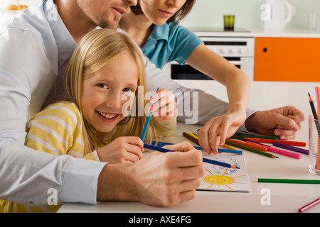 La ragazza (8-9) pittura con i genitori Foto Stock