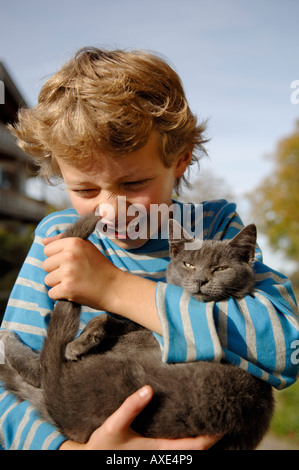 Nove-anno-vecchio ragazzo holding cat Foto Stock