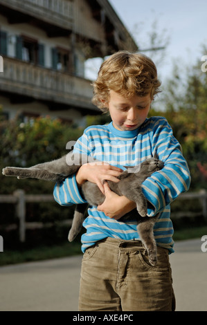 Nove-anno-vecchio ragazzo holding cat Foto Stock