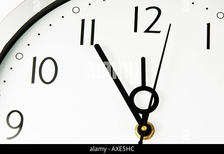 Un orologio da parete mostra cinque minuti prima di dodici, simbolo per data scadenza termine Foto Stock