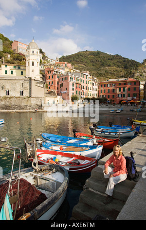 In Italia, la Liguria, Vernazza, Donna seduta sulla fase di atterraggio Foto Stock