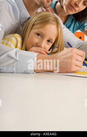 La ragazza (8-9) pittura con i genitori Foto Stock