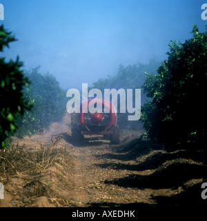 Appannamento alberi di arancio con un trattore disegnato ventilatore motore vicino a Siviglia Spagna Foto Stock