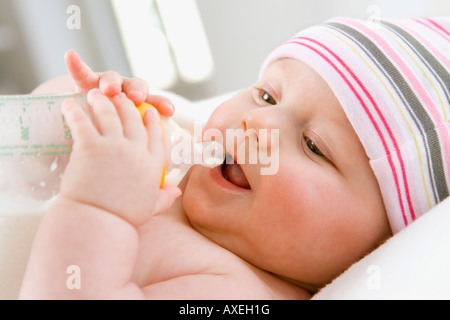 Baby boy (6-9 mesi) bere latte dalla bottiglia, ritratto Foto Stock