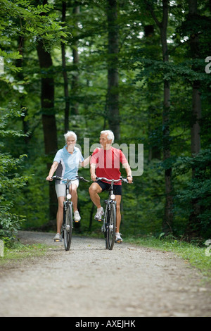 Coppia senior ciclismo su pista forestale Foto Stock