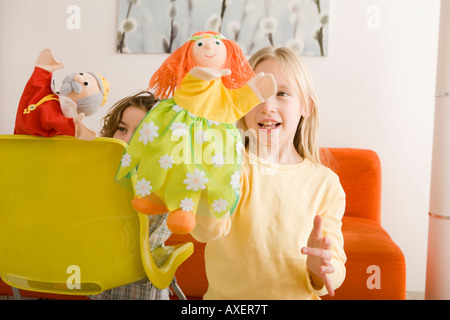 La ragazza (8-9) e ragazzo (6-7) giocando con guanto marionette Foto Stock