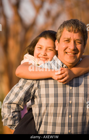 Padre ispanica dando figlia piggyback ride Foto Stock