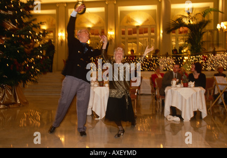 Una coppia di anziani godetevi un tè di Natale danza al London Hotel Waldorf, Aldwych. Foto Stock