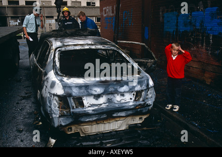 Bruciata auto sotto il Divis Appartamenti di Falls Road a Belfast, Irlanda del Nord e Gran Bretagna, Regno Unito Foto Stock