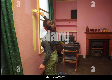 Giovane donna pulizia la sua cucina in casa accovacciata che crebbe in e ha vissuto per 30 anni. Foto Stock