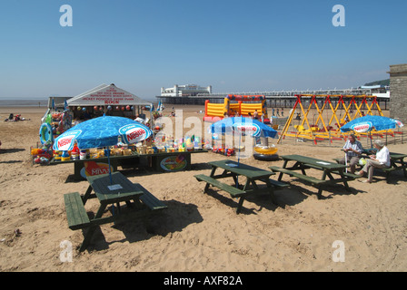 Weston Super Mare località balneare principale spiaggia con stand estate negozio e vacanzieri godendo di tavoli da picnic molo oltre Somerset Inghilterra UK Foto Stock