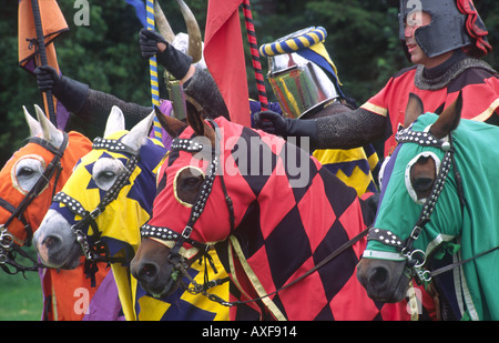 Cavalieri medievali a cavallo in armatura medievale concorrenza giostre ri emanazione al Caerlaverock Castle Dumfries Scozia UK Foto Stock