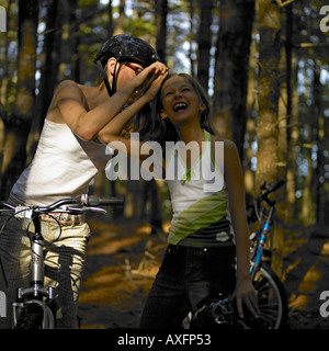 Due ragazze in bici in posa di boschi Foto Stock