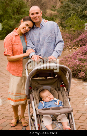 I genitori di origine ispanica con il bambino nel passeggino Foto Stock