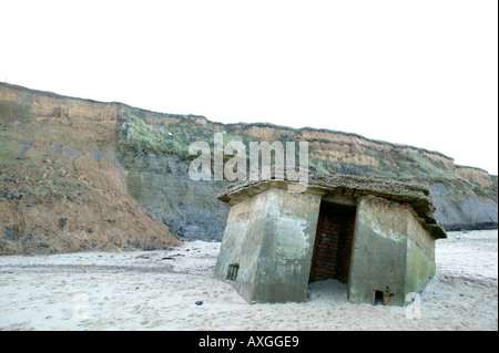 II Guerra Mondiale "scatola di pillole' sulla spiaggia come un risultato di erosione costiera, Happisburgh, Norfolk, Regno Unito Foto Stock